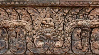 Banteay Srei - Lintel Dieser Giebel stellt Shiva in seiner Mitte dar, der über einer Darstellung von Kala sitzt / This pediment represents Shiva, at its centre, seated above a...